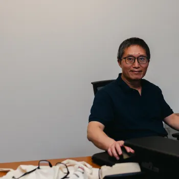 OSATT member smiling from behind computer