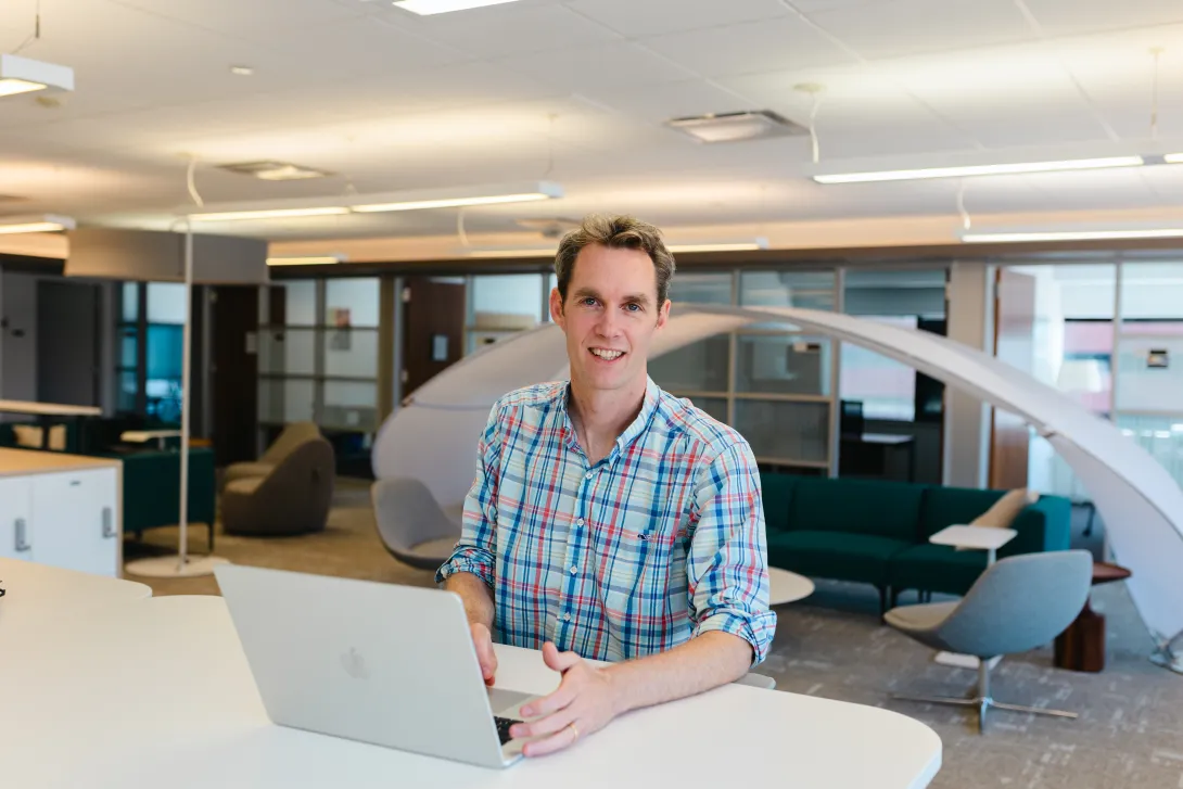 OSATT member smiling from behind computer